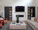 Bright and airy living room space featuring a recessed linear fireplace with an arcusstone surround. Contrasting built ins mimic the tones of the kitchen adjacent. 