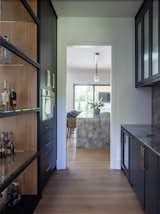 Liquor display and bar featuring italian marble tops and splash that offer a peek into the kitchen and outdoor living space. 