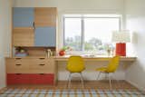 In the office space, we designed wood, flat panel cabinets and a built-in desk that highlights the amazing views of the California hillside.  Pops of persimmon feel playful, along with the curves of Eames molded chairs.