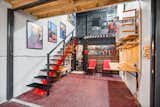 open area with staircase to second floor. The kitchen is behind the glass windows