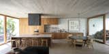 Kitchen, Stone Slab Backsplashe, Refrigerator, Wood Counter, Cooktops, Concrete Floor, Ceiling Lighting, Wood Cabinet, Wall Oven, and Range Hood  Photo 8 of 23 in Casa Nicaragua by Julia Muñoz Osorio