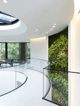 A lush, green living wall spanning two floors along the interior wall imparts a natural ambiance within the space.