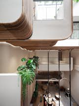 A vantage view from the second level of the atrium, revealing the guest corridor alongside the wooden planter, encapsulating the serene and organic ambiance that flows through the levels of Double B Hostel.