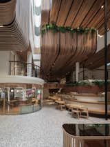 The atrium, where the frontal facade and interior reclaimed wood planter unite, embodying Double B Hostel's blend of modern design and natural elements.