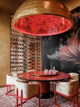 VIP room 2 in richer red and golden tones connected to the main dining through a see through 4 m tall wine display. Traditional round table with lazy susan is anchored with a giant golden dome. Inside this dome is adorned with hand painted motifs of ancient Chinese villages. 
Printed silk screen with abstract image of a phoenix. Creation of this image was commissioned especially for MUME.