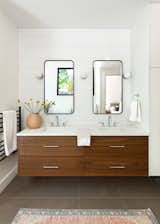 Primary suite bathroom showing custom vanity and linen cabinetry.