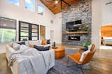 Living Room: High ceilings, a 75" TV with 3.1 Dolby soundbar and subwoofer, massive stone fireplace, seating for 10 and a larger ceiling fan.
