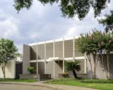 Exterior, Stucco Siding Material, Mid-Century Building Type, House Building Type, Metal Siding Material, Glass Siding Material, Flat RoofLine, and Wood Siding Material After: 2023 photo of new landscaping walls, sun screens and restored stucco from Meyerwood Drive.  Photo 1 of 48 in Style in Steel Townhouse Historic Renovation by Philip LeBlanc