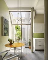 Kitchen, Ceramic Tile Backsplashe, Ceramic Tile Floor, Marble Counter, Accent Lighting, White Cabinet, Pendant Lighting, and Table Lighting After: 2023 photo of kitchen seating area looking to shared a courtyard with painting by Bradley Kerl.  Photo 9 of 48 in Style in Steel Townhouse Historic Renovation