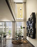 Dining Room, Brick Floor, Pendant Lighting, Floor Lighting, Accent Lighting, Lamps, Table, Ceiling Lighting, and Chair After: 2023 photo of two-story dining room volume looking to forecourt beyond with light sculpture by Michael John Smith on right.  Photo 11 of 48 in Style in Steel Townhouse Historic Renovation by Philip LeBlanc