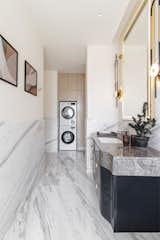 The utility area abutting the bathroom where the washer and dryer are stored. Ample amount of storage units have been added here along with a separate storage space for the cleaning appliances.