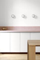 Kitchen, Stone Counter, Wood Cabinet, Wall Lighting, White Cabinet, Range, and Medium Hardwood Floor Detail of the terrazzo counter top  Photo 2 of 10 in The NICE project - an appartement by the beach in Marseille by PAREIL