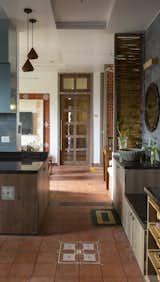 Kitchen, Terra-cotta Tile Floor, Pendant Lighting, Granite Counter, Cooktops, Undermount Sink, Laminate Cabinet, and Stone Tile Backsplashe The perspective of simple living  Photo 8 of 27 in The Pot House by Tina Kedia