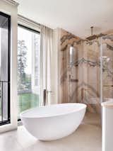 Bath Room, Freestanding Tub, Porcelain Tile Floor, Full Shower, Marble Wall, and Ceiling Lighting Marble is used in the decoration of the master bathroom.  Photo 17 of 20 in Charming apartment with a touch of Bali's serenity by Maria Ushakova by Anna Maria Abara