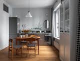 Kitchen, Ceramic Tile Backsplashe, Metal Cabinet, Medium Hardwood Floor, Refrigerator, Pendant Lighting, Wall Oven, and Drop In Sink A German vintage lamp from the 1970s in the kitchen.  Photo 6 of 19 in The graphic apartment of 40 sqm by decorator Margo Terentyeva by Anna Maria Abara