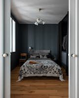 Bedroom, Bed, Pendant Lighting, Medium Hardwood Floor, Chair, Wall Lighting, Storage, and Wardrobe A Soviet chandelier from around the 1950s in the bedroom.  Photo 15 of 19 in The graphic apartment of 40 sqm by decorator Margo Terentyeva by Anna Maria Abara