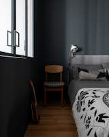 Bedroom, Chair, Medium Hardwood Floor, and Bed Bed sconce by Ikea.  Photo 16 of 19 in The graphic apartment of 40 sqm by decorator Margo Terentyeva by Anna Maria Abara