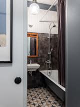 Bath Room, Ceramic Tile Wall, One Piece Toilet, Wall Mount Sink, Open Shower, Ceramic Tile Floor, and Wall Lighting Sink by Jacob Delafon, faucets by D&K.  Photo 17 of 19 in The graphic apartment of 40 sqm by decorator Margo Terentyeva by Anna Maria Abara