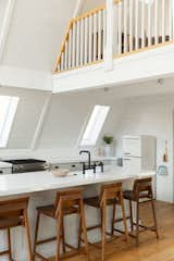 Kitchen, Drop In Sink, Refrigerator, Quartzite Counter, Light Hardwood Floor, White Cabinet, Ceiling Lighting, and Range  Photo 2 of 14 in A-Frame Haus by Kara James