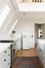 Kitchen, Drop In Sink, Refrigerator, Ceiling Lighting, White Cabinet, Quartzite Counter, and Light Hardwood Floor  Photo 4 of 14 in A-Frame Haus by Kara James
