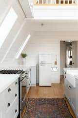 Kitchen, Drop In Sink, Refrigerator, Ceiling Lighting, White Cabinet, Quartzite Counter, and Light Hardwood Floor  Photo 4 of 14 in A-Frame Haus