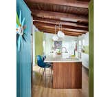 Pops of Mediterranean blue and Parakeet green complement the natural elements in the kitchen.