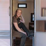 Interior Designer and fabricator, Kelly Lockwood Padgett, sits in the doorway of the Play Mor Trailer. 