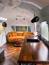 Kitchen, Wood Counter, Wood Cabinet, Accent Lighting, Medium Hardwood Floor, Drop In Sink, Floor Lighting, Metal Cabinet, Refrigerator, Microwave, Pendant Lighting, Recessed Lighting, and Ceiling Lighting  Photo 4 of 5 in The Farmhouse Office Airstream by Wood & Locks