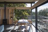 The glass walls slide open to connect the space to the garden and trees.