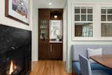 Dining Room, Bench, Gas Burning Fireplace, Medium Hardwood Floor, and Two-Sided Fireplace In the dinette, we introduced a sleek granite surround fireplace that exudes contemporary elegance.  Photo 2 of 8 in Spanish Colonial by Quartersawn Design Build