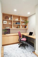 An L-shaped desk gives plenty of work space while also creating symmetry with the shelves above.