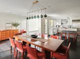 In this angle of the dining and kitchen area, the red accents are the most prominent and tie both spaces together.