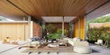 Living Room, Ottomans, Chair, Table Lighting, Coffee Tables, Ceiling Lighting, Medium Hardwood Floor, Hanging Fireplace, Bench, Sofa, and Wood Burning Fireplace  Photo 3 of 11 in Aviator's House by Castellari Arquitetura