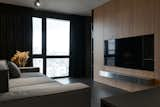 Living Room, Shelves, Dark Hardwood Floor, Sofa, Media Cabinet, and Track Lighting  Photo 4 of 17 in Hoffman Apartment by Shovk Studio