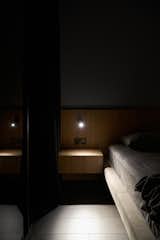 Bedroom, Dark Hardwood Floor, Wall Lighting, Night Stands, and Bed  Photo 17 of 17 in Hoffman Apartment by Shovk Studio