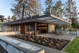 Outdoor, Grass, Hardscapes, Trees, Shrubs, Concrete Patio, Porch, Deck, Small Patio, Porch, Deck, Front Yard, Concrete Fences, Wall, Large Patio, Porch, Deck, and Landscape Lighting View of the home facing the lake/courtyard  Photo 1 of 8 in Seward Park Lake House by E. Cobb Architects