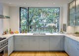 Kitchen, Recessed Lighting, Stone Slab Backsplashe, Light Hardwood Floor, Undermount Sink, Range, Marble Counter, Ceiling Lighting, Pendant Lighting, and Wood Cabinet Kitchen with view to patio  Photo 9 of 11 in Dutch Light by E. Cobb Architects
