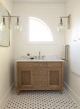 This ensuite guest bathroom was busy with wall murals and bird hardware. We chose a natural oak Pottery barn vanity with a marble countertop to soften the space, along with pewter wall sconces by Palecek and brushed nickel hardware. 