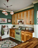 Kitchen with vintage avocado stove and custom rattan cabinets 