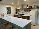 Kitchen, Drop In Sink, Ceiling Lighting, Microwave, Concrete Floor, Ceramic Tile Backsplashe, Wall Lighting, Engineered Quartz Counter, Colorful Cabinet, Range, Wood Cabinet, Range Hood, and Refrigerator Kitchen   Photo 6 of 12 in Moonlight Pines by Bre Derby