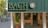 The facade of this store is a sight to behold, clad in yellow particle board. Against this background the branding stands out in a striking contrast of a forest green shade, adding a contemporary twist to the traditional aesthetics along with brushed brass look letters to invoke a rustic essence