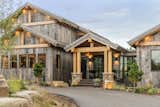 Rustic lodge vibes, covered front entry, exterior design. Reclaimed wood siding, corrugated metal roofs. Sustainable, natural materials, biophilic design. Skyway bridge over waterfall, luxury water feature.