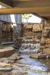 Outdoor and Garden Rustic lodge vibes, covered front entry, exterior design. Sustainable, natural materials, biophilic design. Skyway bridge over waterfall, luxury water feature.  Photo 8 of 101 in Modern Montana by JMAD