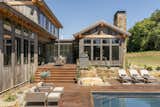 Rustic lodge vibes, covered front entry, exterior design. Reclaimed wood siding, corrugated metal roofs. Sustainable, natural materials, biophilic design. Backyard pool, outdoor living area, patio, grilling area, outdoor dining area, exterior staircase. 