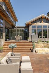 Rustic lodge vibes, covered front entry, exterior design. Reclaimed wood siding, corrugated metal roofs. Sustainable, natural materials, biophilic design. Backyard pool, outdoor living area, patio, grilling area, outdoor dining area, exterior staircase. 