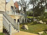 Exterior staircase, custom metal railing, custom lampposts. Luxury terrace outdoor living area. Boulder landscaping.