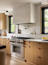 Modern Kitchen, White oak cabinets, zellige tile, tiled hood, black windows, marble countertops, pot filler, marble shelf, range