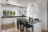 Kitchen, White Cabinet, Wine Cooler, Marble Counter, Microwave, Marble Backsplashe, Undermount Sink, Wall Oven, Dishwasher, Stone Counter, Wood Cabinet, Medium Hardwood Floor, Refrigerator, and Pendant Lighting  Photo 9 of 37 in The Gordon's house by HILA ALTER