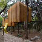 Outdoor, Wood Fences, Wall, Back Yard, Landscape Lighting, Wood Patio, Porch, Deck, Metal Patio, Porch, Deck, Trees, and Decking Patio, Porch, Deck Exterior view: play equipment such as a slide and swings were incorporated into the structures.  Photo 2 of 12 in Las Casitas by Ada Corral