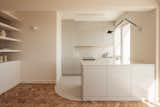 Kitchen, Ceiling Lighting, Marble Backsplashe, Wall Lighting, Refrigerator, Concrete Floor, Wall Oven, Marble Counter, Colorful Cabinet, Dishwasher, and Drop In Sink Open Kitchen  Photo 11 of 23 in Curves of Progress: A Contemporary Rehabilitation in Graça, Lisbon by blaanc